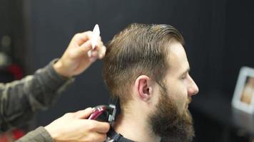 barberare trimmer hår av manlig klient med hårkam och klippare video