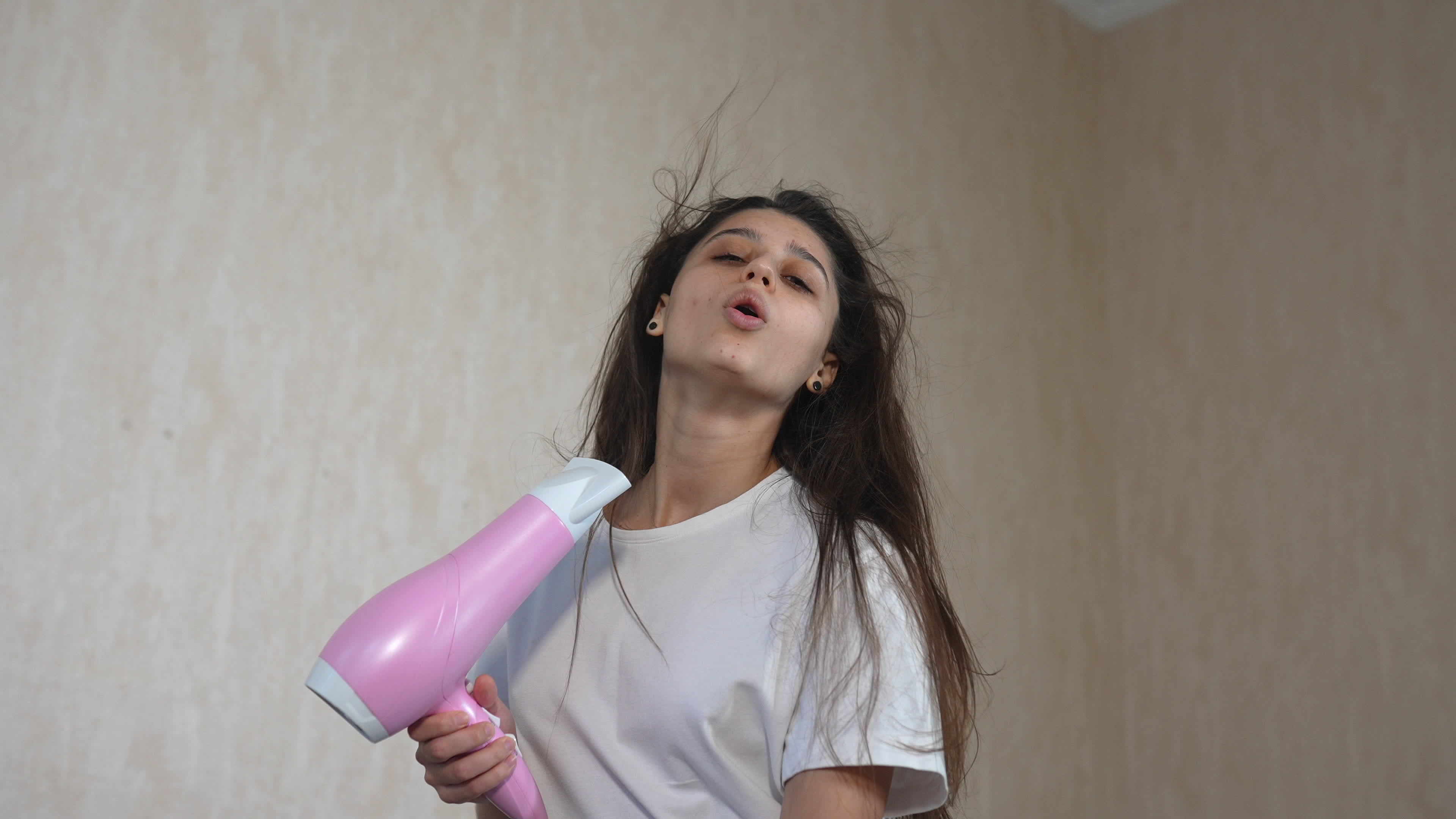 Woman blow drying hair making eye contact and blows a kiss 10941294 Stock Video at Vecteezy