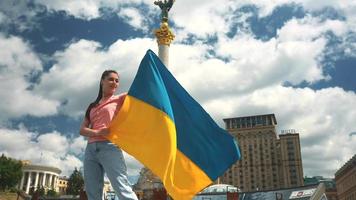 Young woman holds and waves flag of Ukraine in downtown Kyiv video