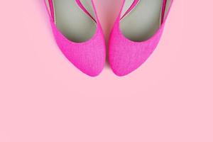Pair of pink classic elegant shoes isolated on pink background with copy space photo