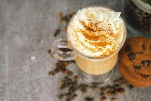 café con leche con caramelo helado en un vaso alto con crema batida. foto