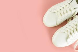 White sneakers on pink background photo