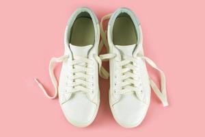 zapatillas blancas sobre fondo rosa foto