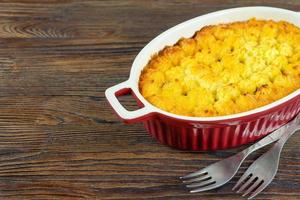 Shepherd's Pie or Cottage Pie, traditional British dish on brown wooden background photo