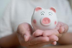 Hands holding piggy bank. Saving concept with piggy bank indoor photo