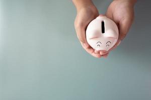 Adult hands holding a piggy bank in savings concept photo