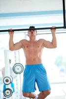 apuesto joven trabajando en el gimnasio foto