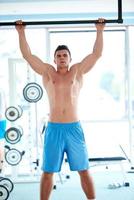 apuesto joven trabajando en el gimnasio foto