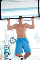 apuesto joven trabajando en el gimnasio foto