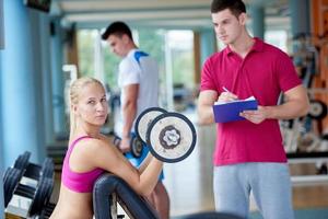 young sporty woman with trainer exercise weights lifting photo