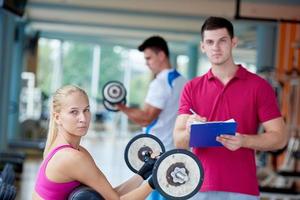 young sporty woman with trainer exercise weights lifting photo