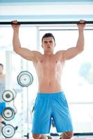 handsome young mand working out in gym photo