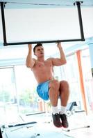 apuesto joven trabajando en el gimnasio foto