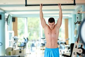 apuesto joven trabajando en el gimnasio foto