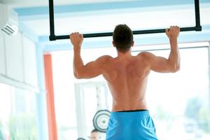 apuesto joven trabajando en el gimnasio foto