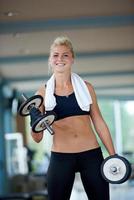 lifting some weights and working on her biceps in a gym photo