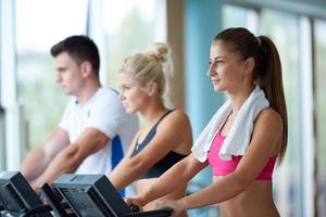 friends  exercising on a treadmill at the bright modern gym photo