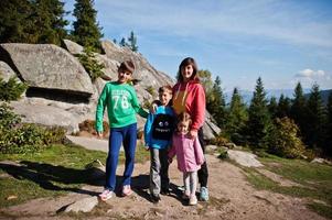 madre con cuatro hijos descansando en las montañas. viajes familiares y senderismo con niños. foto