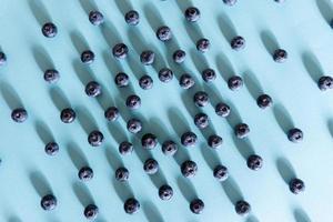 Fresh juicy blueberries on blue background, flat lay with copy space. Blueberries background photo