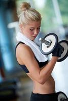 lifting some weights and working on her biceps in a gym photo