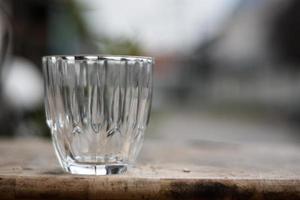 vaso vacío en la mesa de madera oscura fondo borroso. foto