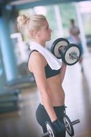 levantando pesas y trabajando en sus bíceps en un gimnasio foto