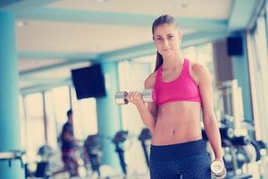 lifting some weights and working on her biceps in a gym photo