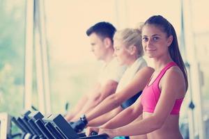 amigos haciendo ejercicio en una cinta de correr en el moderno y luminoso gimnasio foto