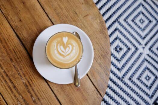 vista superior del café con leche caliente en la mesa de madera con fondo de patrón de piso de arte foto