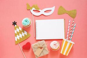 Cute party props, cake, blank notebook and gift box on colorful background, happy new year party celebration photo