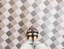 Top view of selfie feet in sandals shoes standing on seamless floor background with copy space photo