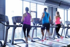 Group of people running on treadmills photo