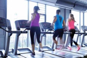 Group of people running on treadmills photo