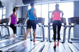 Group of people running on treadmills photo