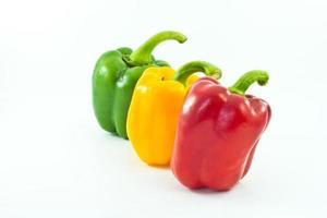 Red, yellow and green bell peppers isolated on the white background photo