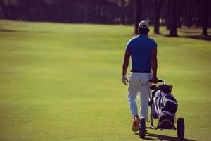 golf player walking with wheel bag photo