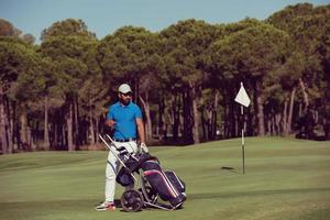 jugador de golf caminando con bolsa de ruedas foto
