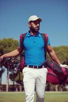 golf player walking and carrying bag photo