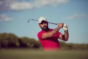 golfer hitting a sand bunker shot photo