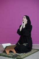 Middle eastern woman praying and reading the holy Quran photo