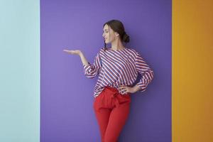 retrato de una joven y bella mujer feliz y sonriente en un gesto de presentación con la palma abierta foto