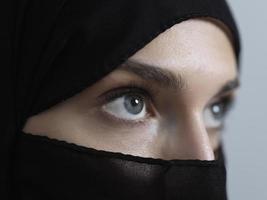 Portrait of muslim woman wearing niqab and traditional arabic clothes or abaya photo