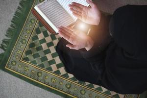 Middle eastern woman praying and reading the holy Quran photo