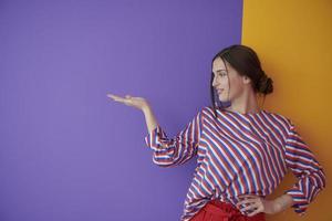 Portrait of happy smiling young beautiful woman in a presenting gesture with open palm photo