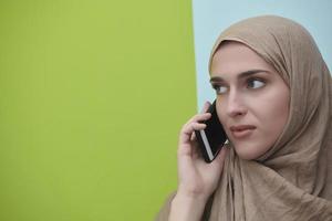 Young muslim girl wearing hijab talking on the phone photo