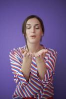 Close up portrait of charrming girl  blowing air kiss from open palm photo
