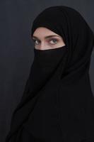 Portrait of muslim woman wearing niqab and traditional arabic clothes or abaya photo