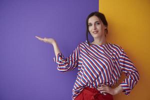 Portrait of happy smiling young beautiful woman in a presenting gesture with open palm photo