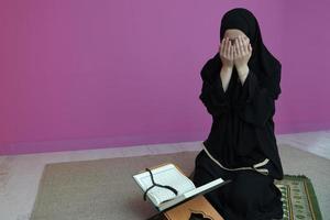 mujer del medio oriente rezando y leyendo el sagrado corán foto