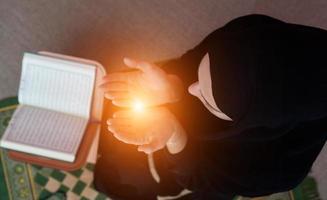 Middle eastern woman praying and reading the holy Quran photo